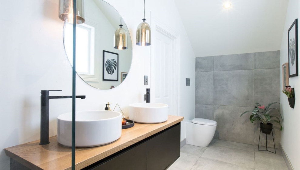 Mid-sized traditional master wet room bathroom in London with flat-panel cabinets, black cabinets, a one-piece toilet, gray tile, ceramic tile, green walls, ceramic floors, a vessel sink, laminate benchtops, grey floor, an open shower, brown benchtops, an enclosed toilet, a double vanity and a floating vanity.