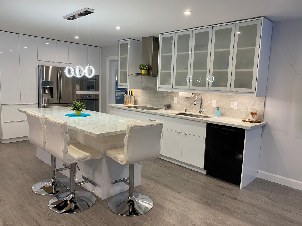 Mid-sized contemporary galley open plan kitchen in Toronto with an undermount sink, glass-front cabinets, white cabinets, quartz benchtops, grey splashback, porcelain splashback, stainless steel appliances, laminate floors, with island, grey floor and multi-coloured benchtop.
