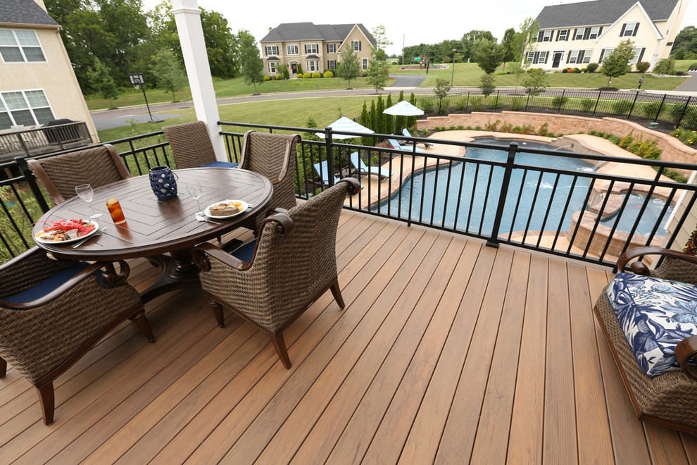 This is an example of a large contemporary backyard deck in Philadelphia with a pergola and an outdoor kitchen.