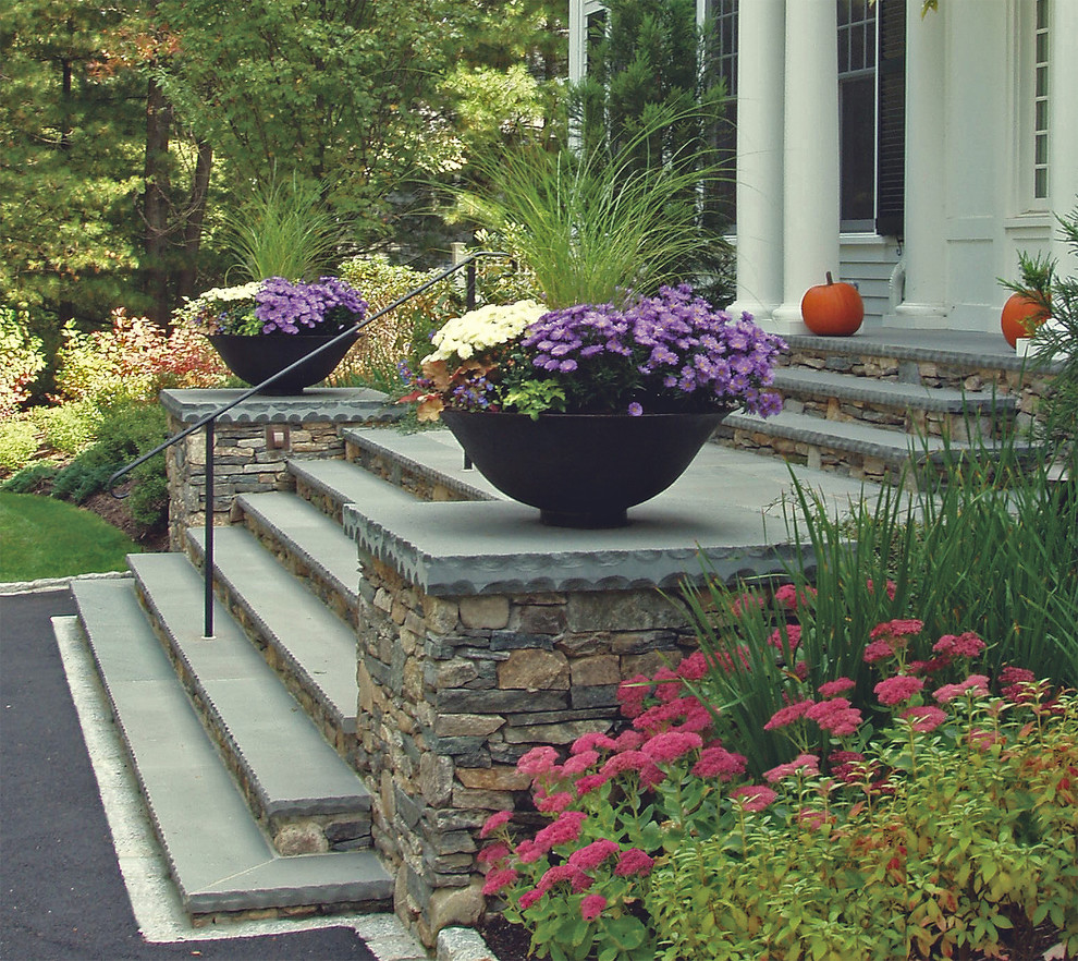 Photo of a large transitional front yard garden in Boston with natural stone pavers.