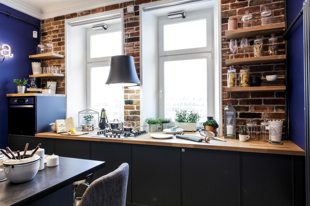 Photo of a small contemporary galley eat-in kitchen in Moscow with flat-panel cabinets, black cabinets, wood benchtops, red splashback, brick splashback, black appliances, with island and beige benchtop.