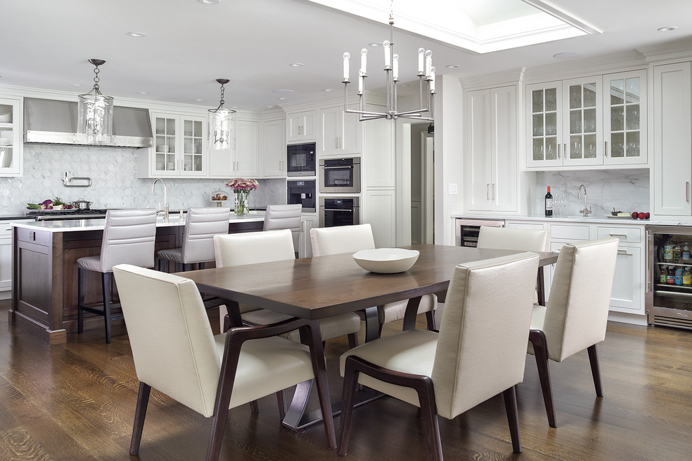 Design ideas for a large traditional u-shaped open plan kitchen in New York with an undermount sink, shaker cabinets, white cabinets, marble benchtops, white splashback, marble splashback, stainless steel appliances, dark hardwood floors, with island, brown floor and white benchtop.