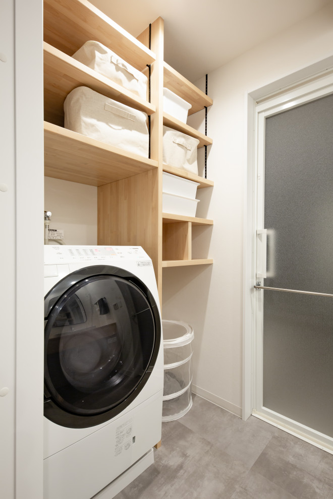 Photo of a mid-sized industrial galley dedicated laundry room in Nagoya with a drop-in sink, open cabinets, light wood cabinets, wood benchtops, beige walls, laminate floors, an integrated washer and dryer, grey floor, beige benchtop, wallpaper and wallpaper.