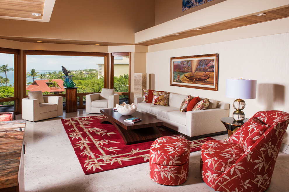 Tropical open concept living room in Hawaii with beige walls and limestone floors.