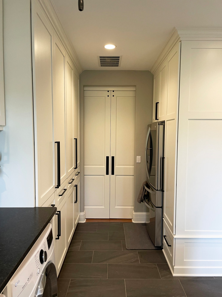 Inspiration for an expansive transitional utility room in Milwaukee with a drop-in sink, shaker cabinets, white cabinets, granite benchtops, grey walls, a side-by-side washer and dryer and black benchtop.