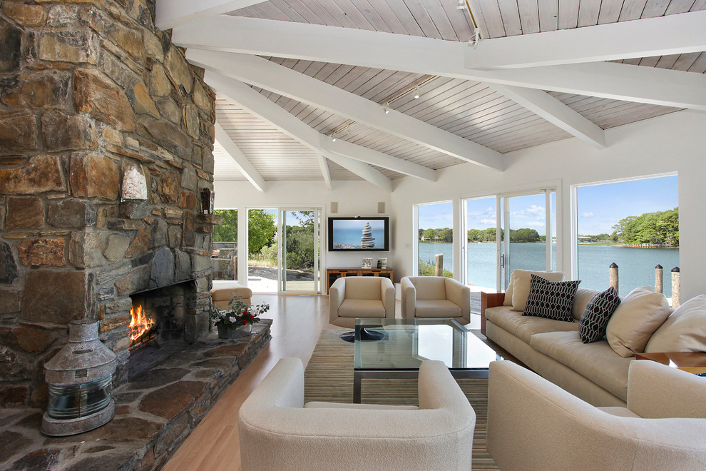 Inspiration for a beach style living room in New York with a standard fireplace and a stone fireplace surround.