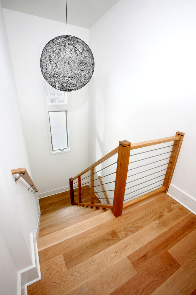 Inspiration for a mid-sized contemporary wood u-shaped staircase in New York with wood risers and wood railing.