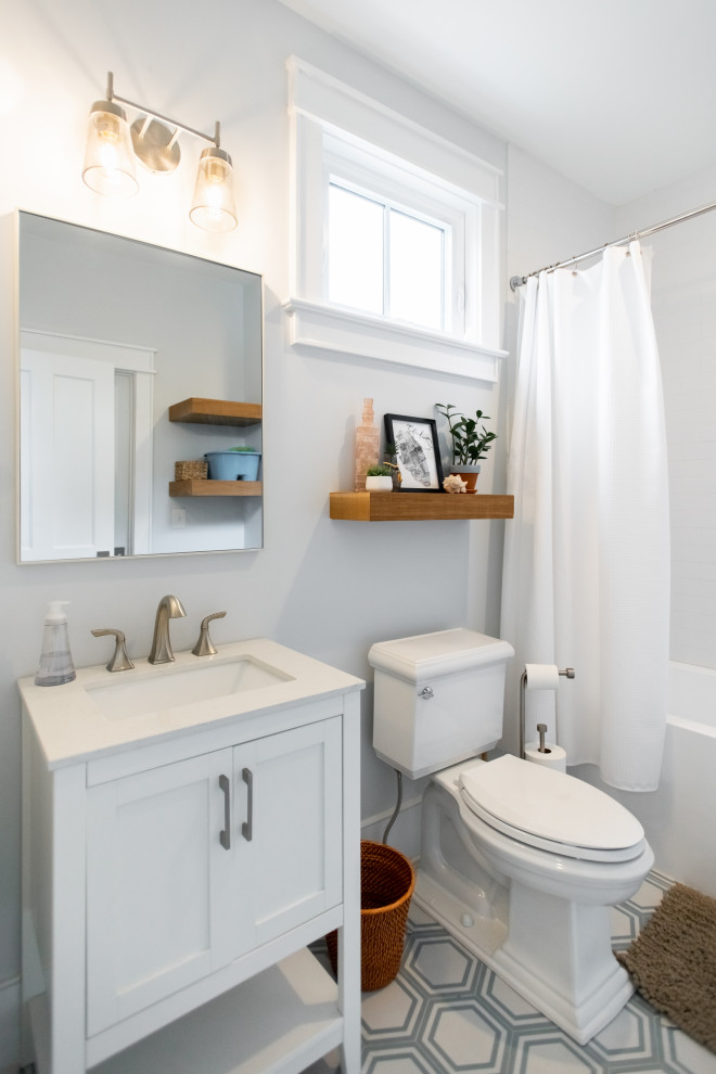 Inspiration for a medium sized classic bathroom in Charleston with white cabinets, an alcove bath, a shower/bath combination, a two-piece toilet, white tiles, grey walls, a submerged sink, multi-coloured floors, a shower curtain, white worktops, a single sink and a freestanding vanity unit.