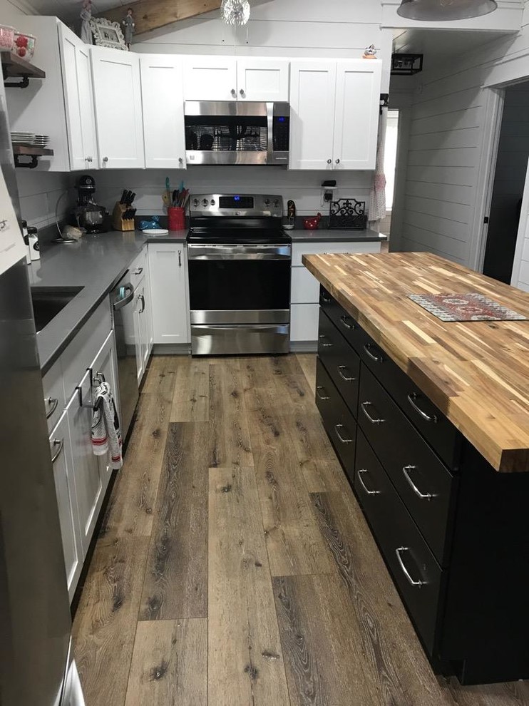Inspiration for a small country l-shaped eat-in kitchen in Atlanta with an undermount sink, shaker cabinets, white cabinets, granite benchtops, white splashback, timber splashback, stainless steel appliances, with island and black benchtop.