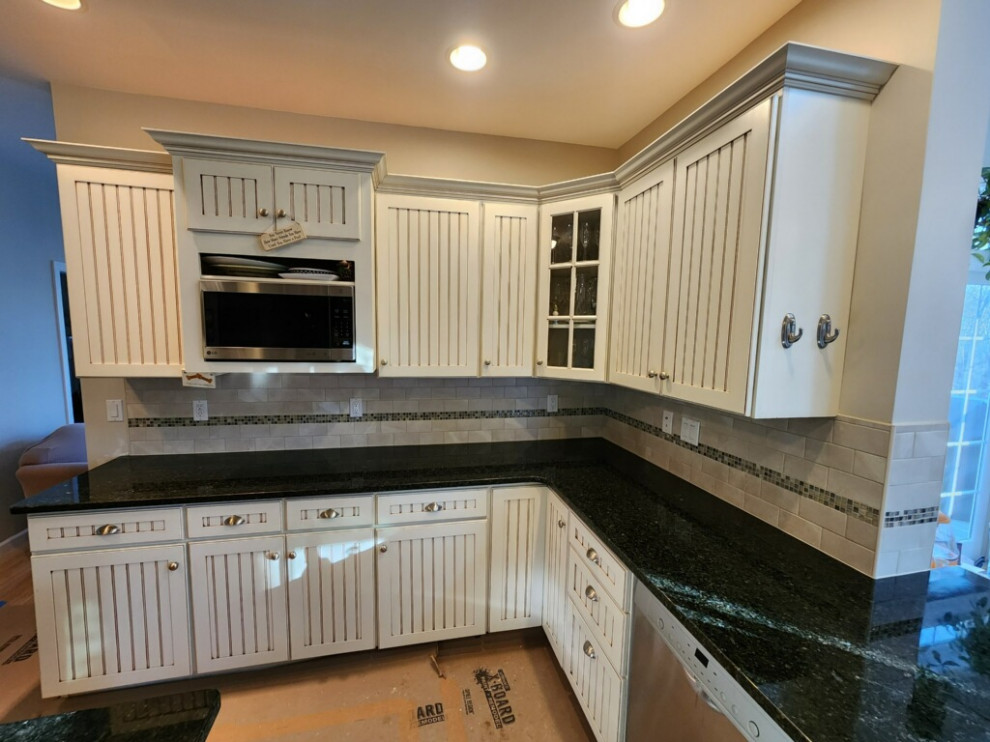Inspiration for a mid-sized arts and crafts l-shaped kitchen pantry in Bridgeport with granite benchtops, beige splashback, subway tile splashback, stainless steel appliances and green benchtop.