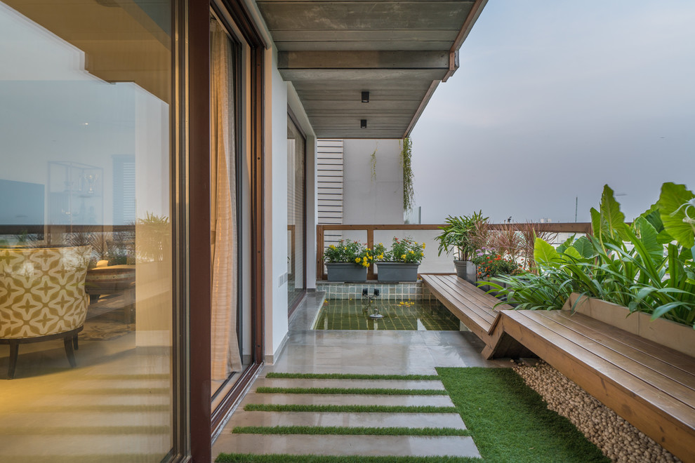 Contemporary balcony in Hyderabad with a container garden, a roof extension and mixed railing.