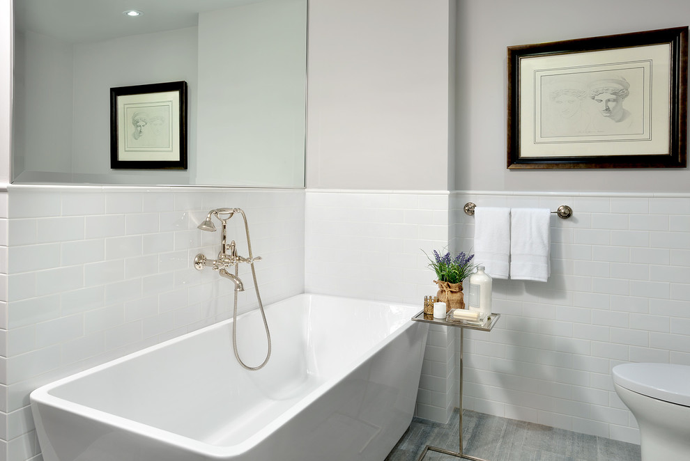 Small transitional 3/4 bathroom in Toronto with furniture-like cabinets, medium wood cabinets, a freestanding tub, an alcove shower, a one-piece toilet, white tile, ceramic tile, grey walls, marble floors, an undermount sink and quartzite benchtops.