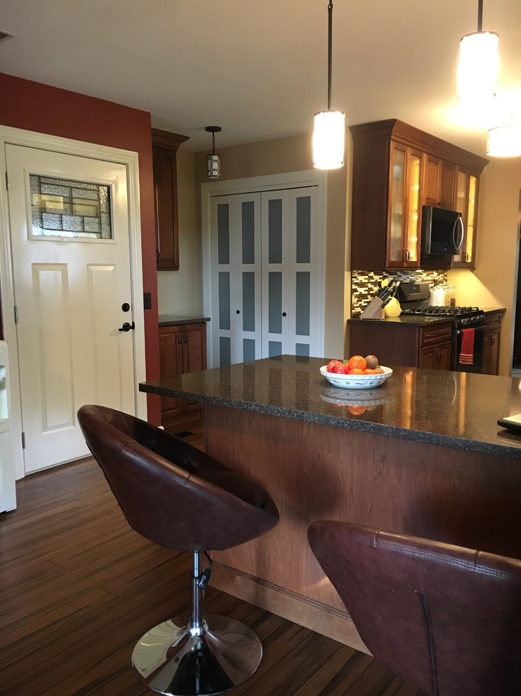 Inspiration for a mid-sized transitional dark wood floor enclosed kitchen remodel in Chicago with an undermount sink, glass-front cabinets, quartz countertops, multicolored backsplash, colored appliances and a peninsula