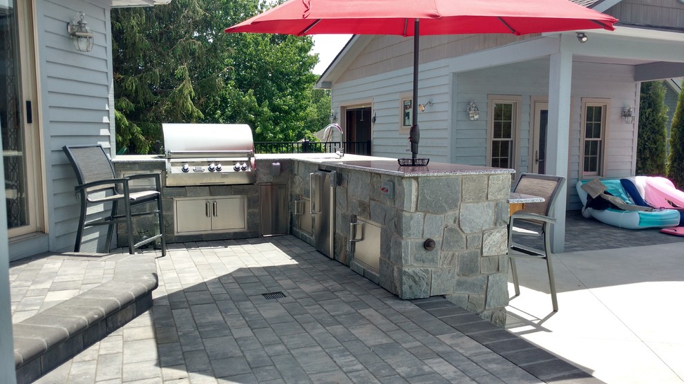 Inspiration for a large traditional backyard patio in Grand Rapids with an outdoor kitchen, concrete pavers and no cover.