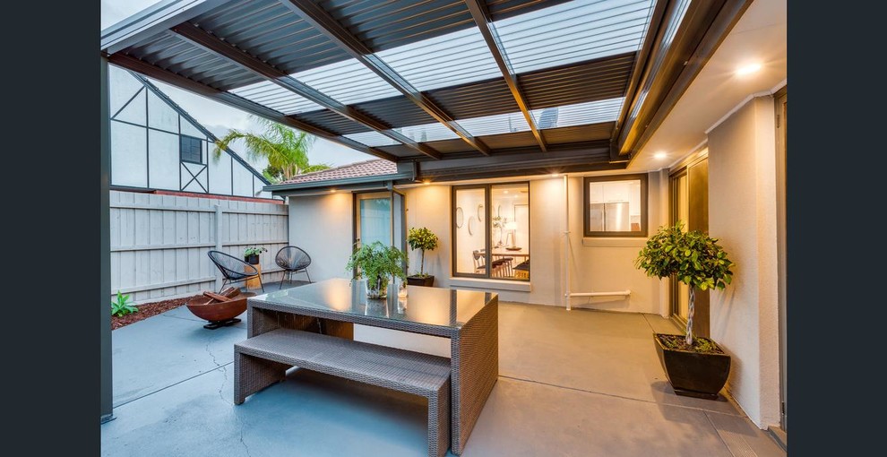 Design ideas for a mid-sized contemporary backyard patio in Melbourne with a fire feature, concrete slab and a pergola.