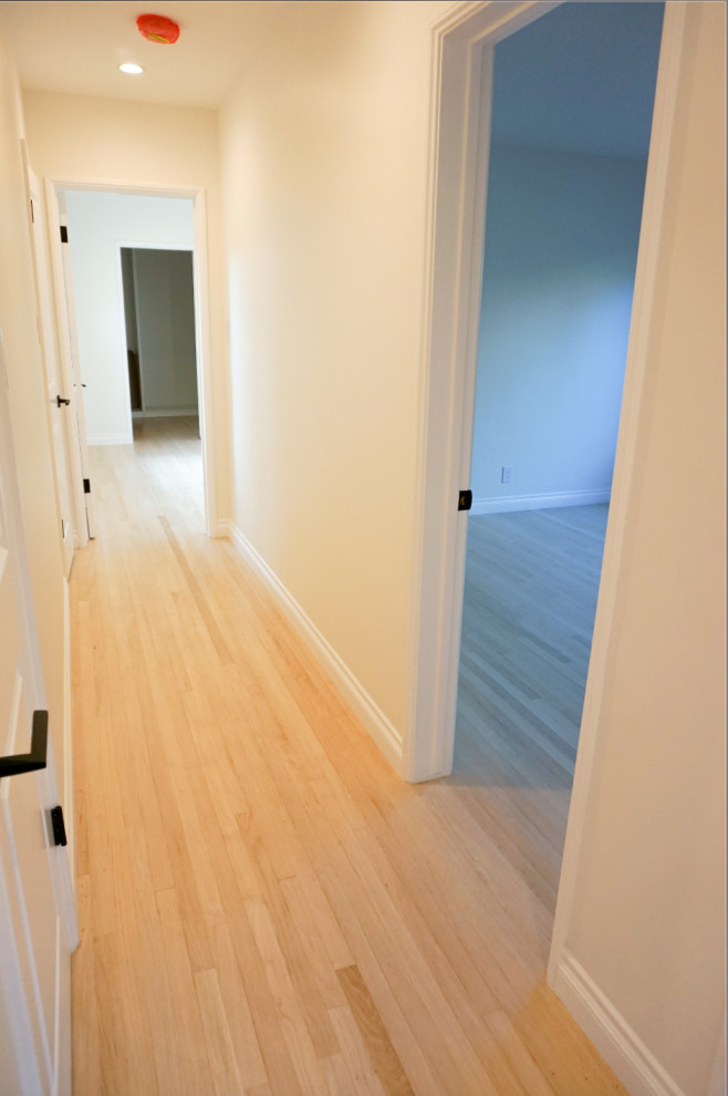 Modern hallway in Los Angeles with white walls, light hardwood floors and beige floor.