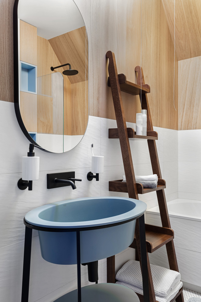 Bild på ett stort funkis badrum för barn, med släta luckor, skåp i ljust trä, ett undermonterat badkar, en dusch/badkar-kombination, en vägghängd toalettstol, vit kakel, vita väggar, mosaikgolv, ett konsol handfat och vitt golv