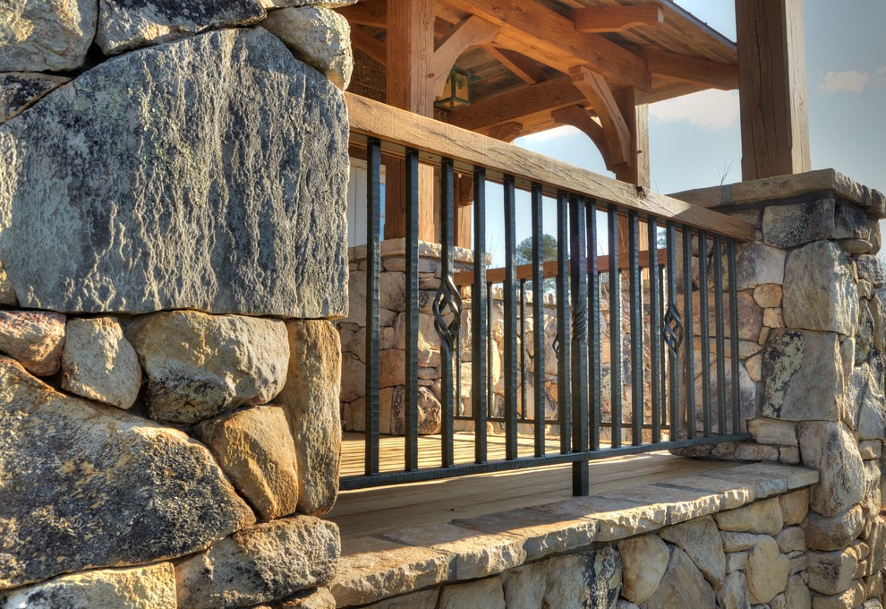 Inspiration for a rustic backyard balcony deck remodel with a roof extension