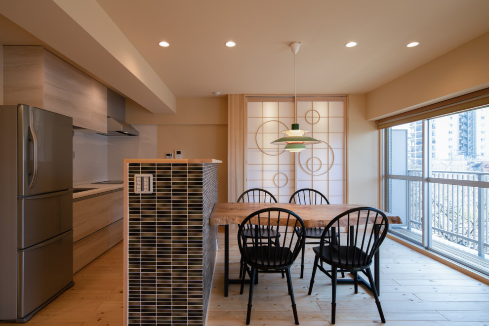 Photo of an eclectic dining room in Other with beige walls, medium hardwood floors, beige floor and wallpaper.
