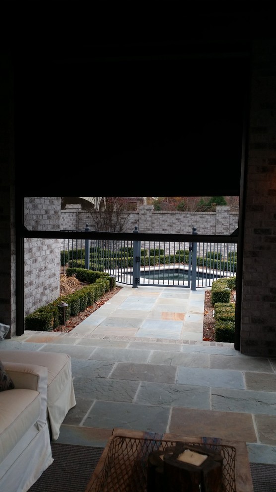 This is an example of a large traditional backyard patio in Louisville with a roof extension, an outdoor kitchen and tile.