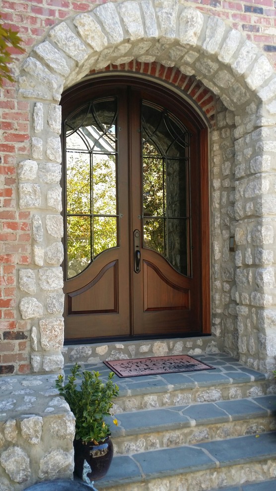 Inspiration for a transitional front door in Charlotte with a double front door and a medium wood front door.