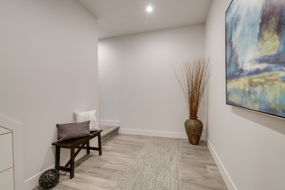 Photo of a large contemporary hallway in Vancouver with white walls, laminate floors and grey floor.