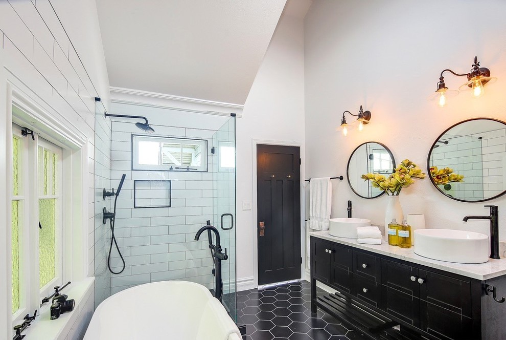 Arts and crafts master bathroom in Seattle with a freestanding tub, a corner shower, white tile, subway tile, white walls, porcelain floors, a vessel sink, engineered quartz benchtops, black floor, a hinged shower door, multi-coloured benchtops and black cabinets.