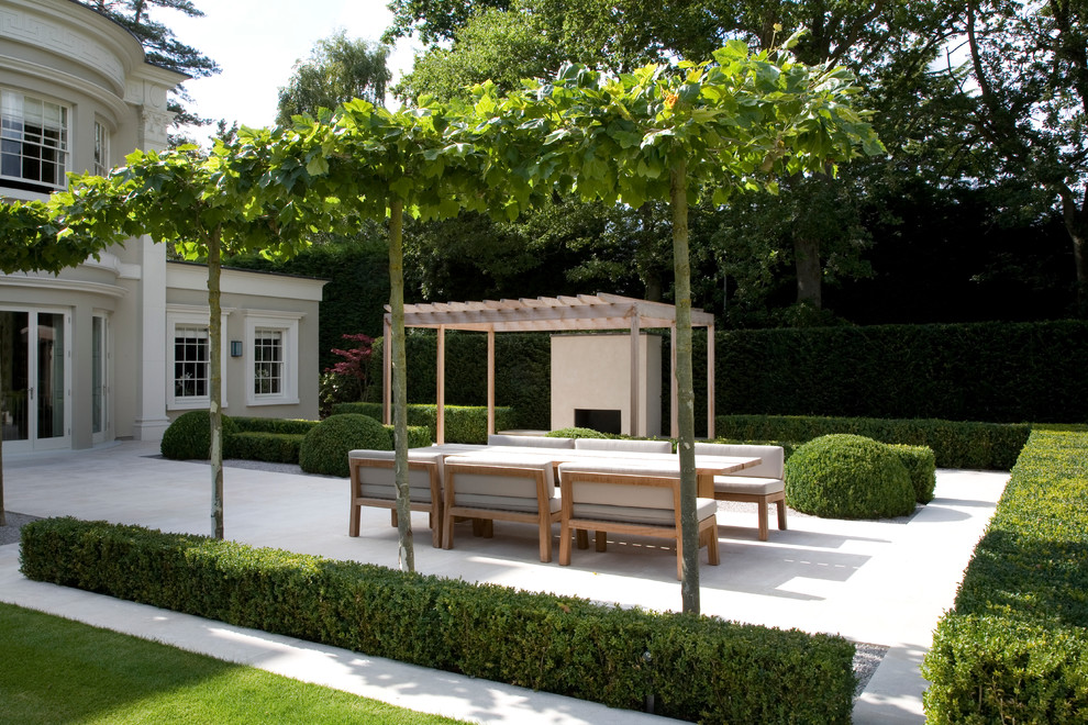 Inspiration for an expansive contemporary backyard patio in Surrey with natural stone pavers and a pergola.