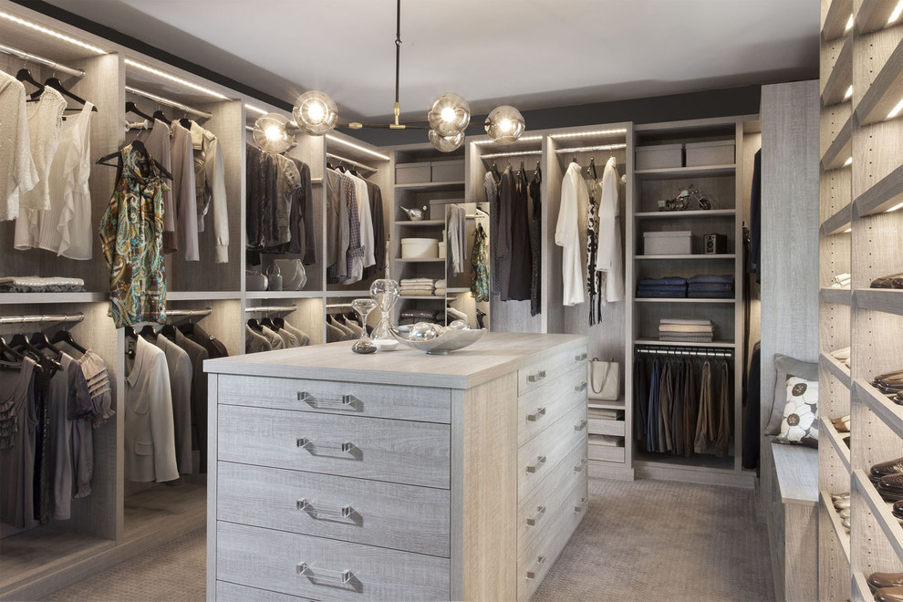 Large transitional gender-neutral dressing room in New York with distressed cabinets, carpet and open cabinets.