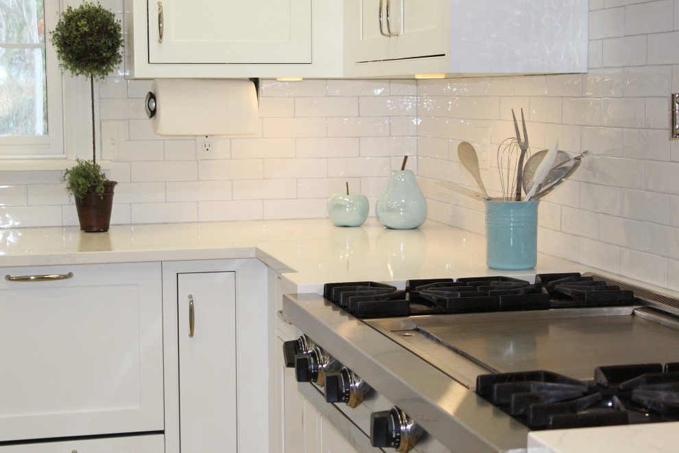 Kitchen - huge medium tone wood floor kitchen idea with beaded inset cabinets, white cabinets, granite countertops, white backsplash, ceramic backsplash, stainless steel appliances, an island and white countertops