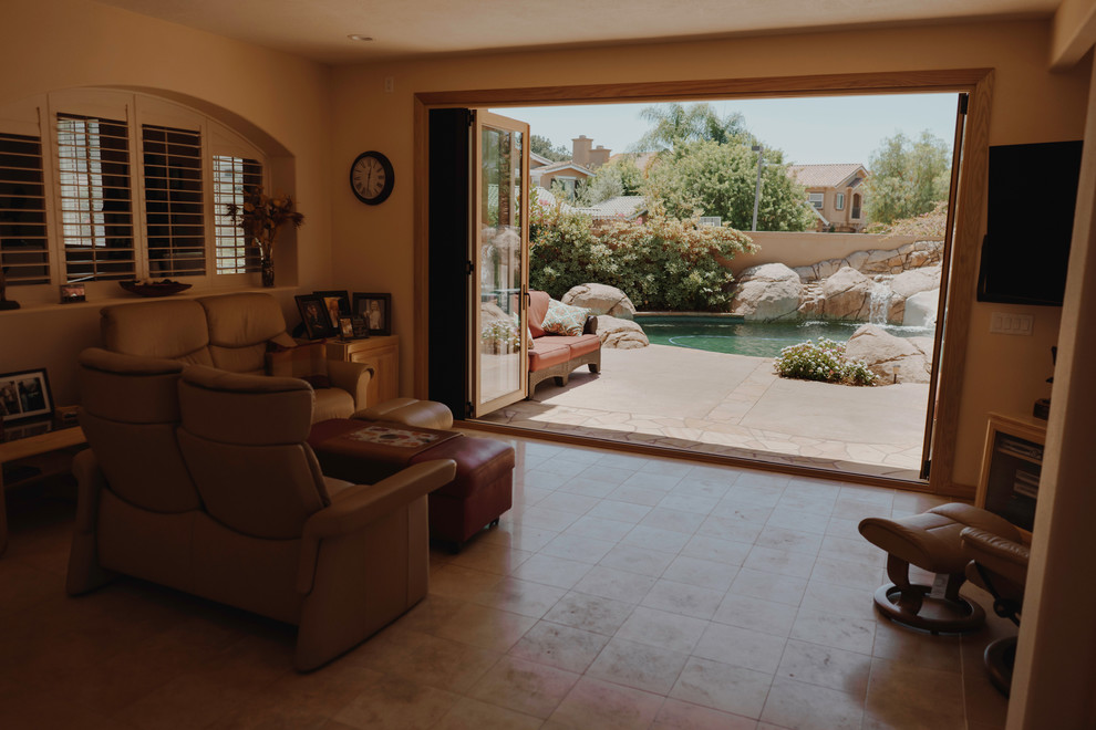 Photo of a small country open concept living room in Orange County with beige walls, travertine floors, no fireplace, a wall-mounted tv and beige floor.