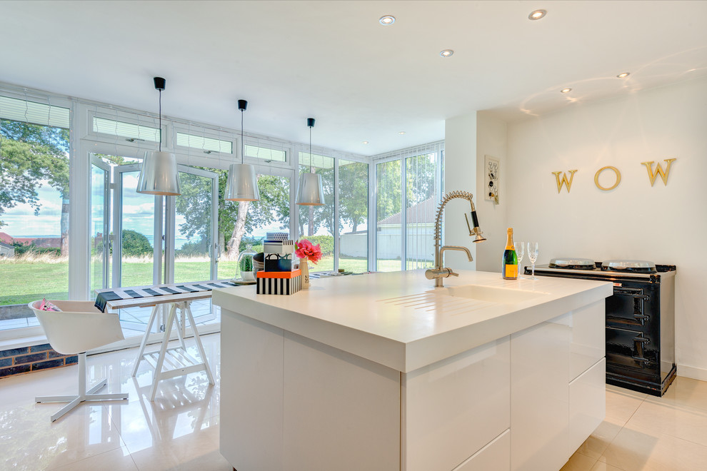 Photo of a large contemporary u-shaped eat-in kitchen in Devon with an integrated sink, flat-panel cabinets, black cabinets, quartz benchtops, white splashback, stainless steel appliances, ceramic floors and with island.
