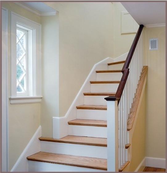 Photo of a small arts and crafts wood curved staircase in Boston with painted wood risers.