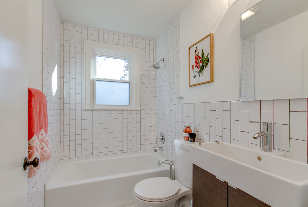 Inspiration for a mid-sized modern bathroom in Nashville with flat-panel cabinets, brown cabinets, an alcove tub, a shower/bathtub combo, a one-piece toilet, white tile, ceramic tile, white walls, a vessel sink, a shower curtain, marble floors and grey floor.