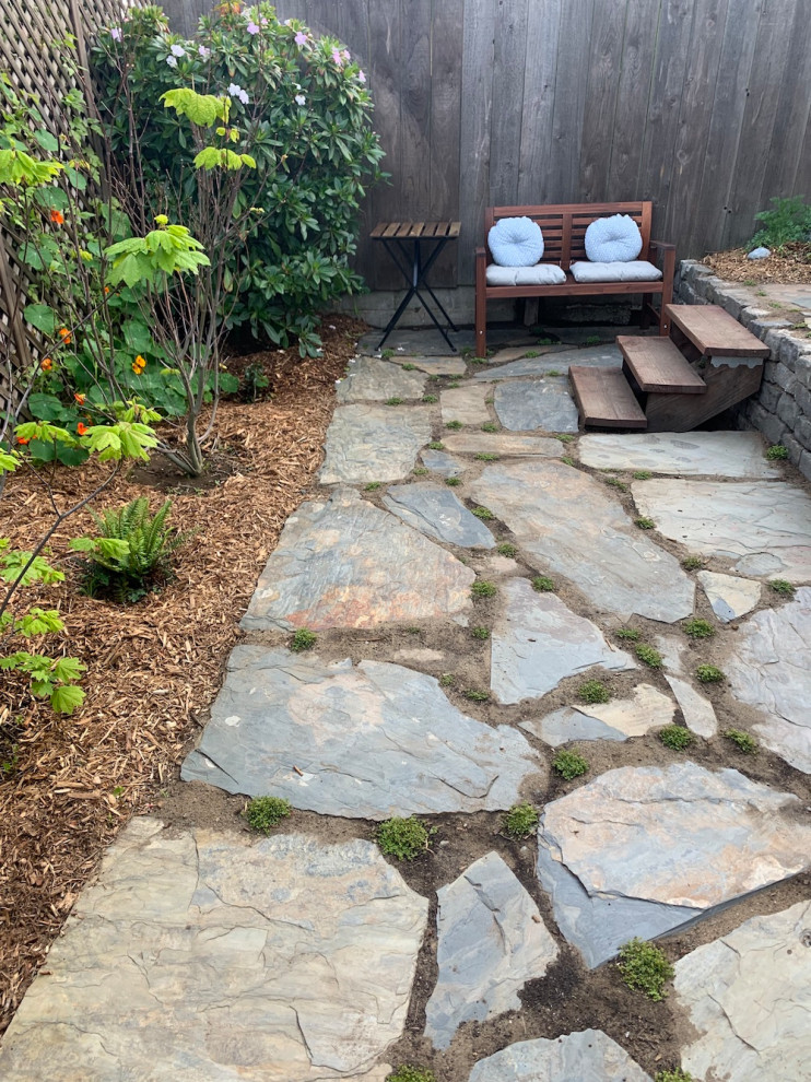 Inspiration for a mid-sized country backyard partial sun xeriscape in San Francisco with with privacy feature and natural stone pavers.