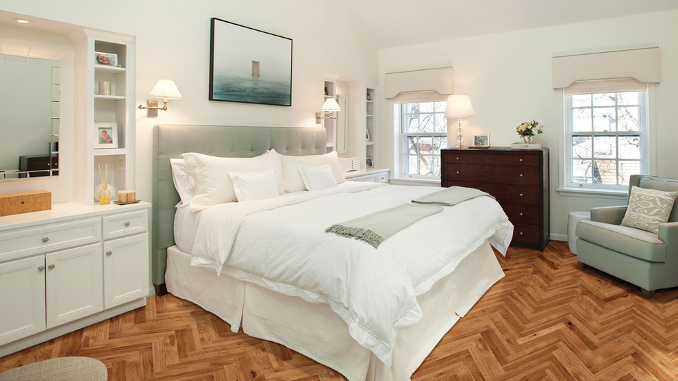 This is an example of a transitional master bedroom in Orange County with white walls and medium hardwood floors.
