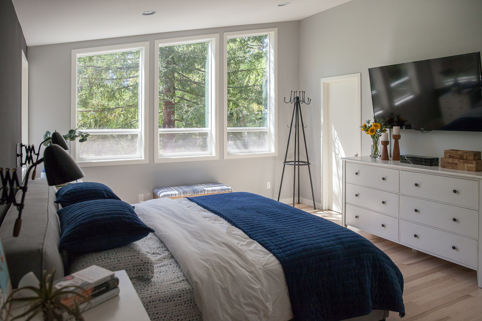 Mid-sized scandinavian master bedroom in Portland with grey walls and light hardwood floors.