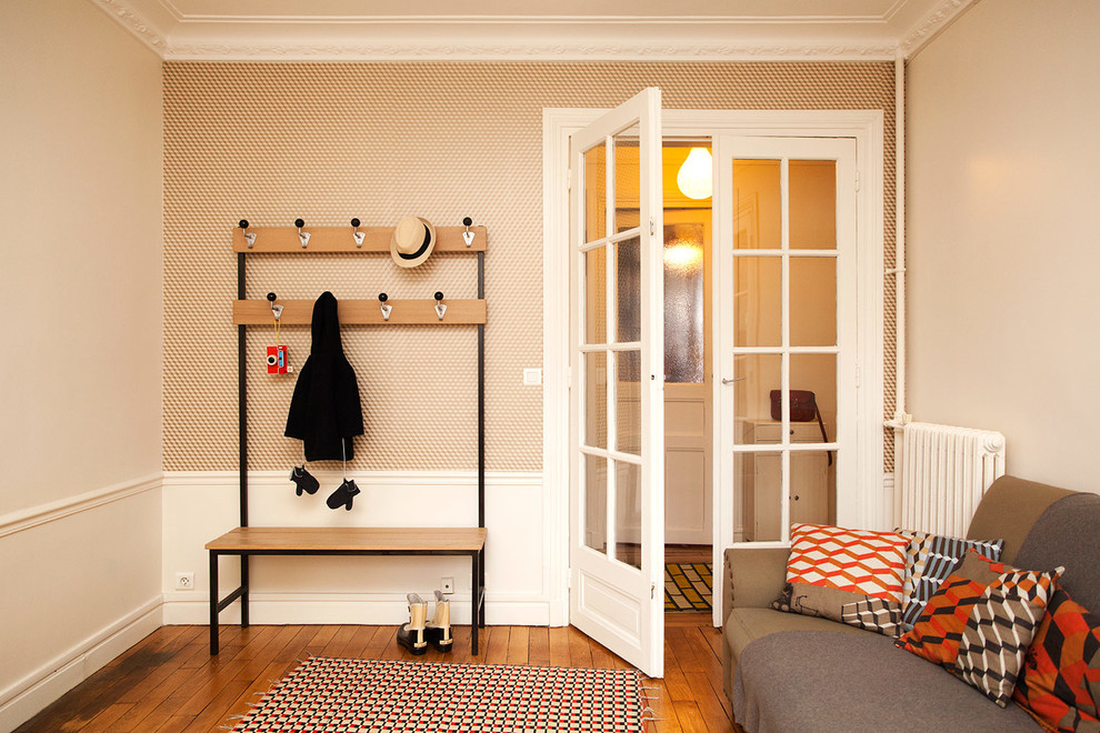 Design ideas for a mid-sized scandinavian mudroom in Paris with orange walls and light hardwood floors.