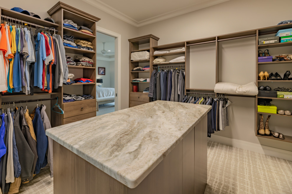 Design ideas for a large transitional gender-neutral walk-in wardrobe in Atlanta with flat-panel cabinets, medium wood cabinets, carpet and beige floor.
