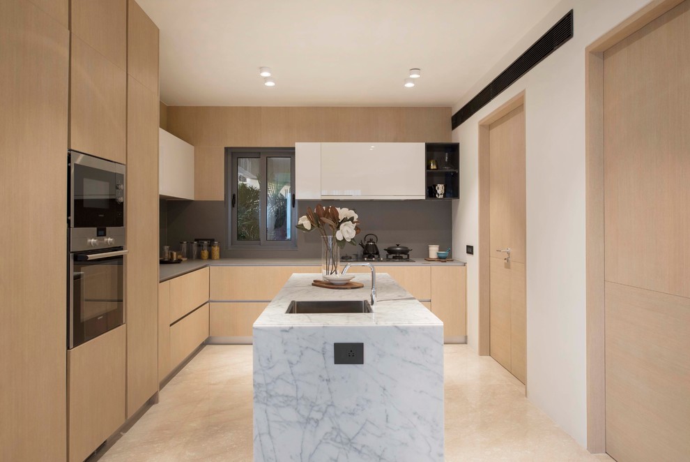 Photo of a contemporary l-shaped kitchen in Singapore with flat-panel cabinets, light wood cabinets, stainless steel appliances, with island, beige floor and white benchtop.