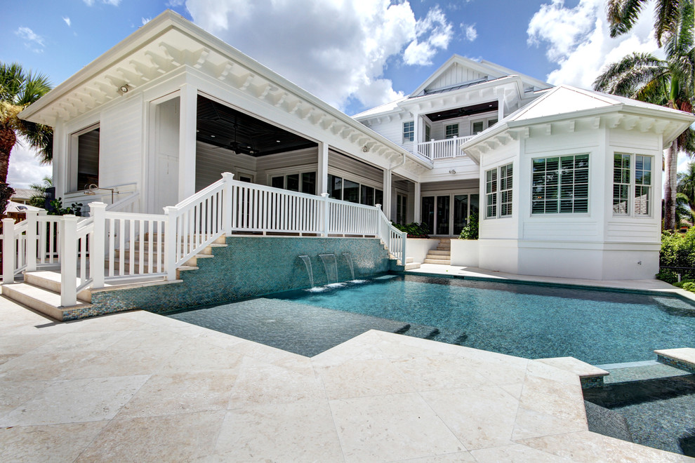 Design ideas for a large beach style backyard custom-shaped pool in Tampa with a water feature and tile.