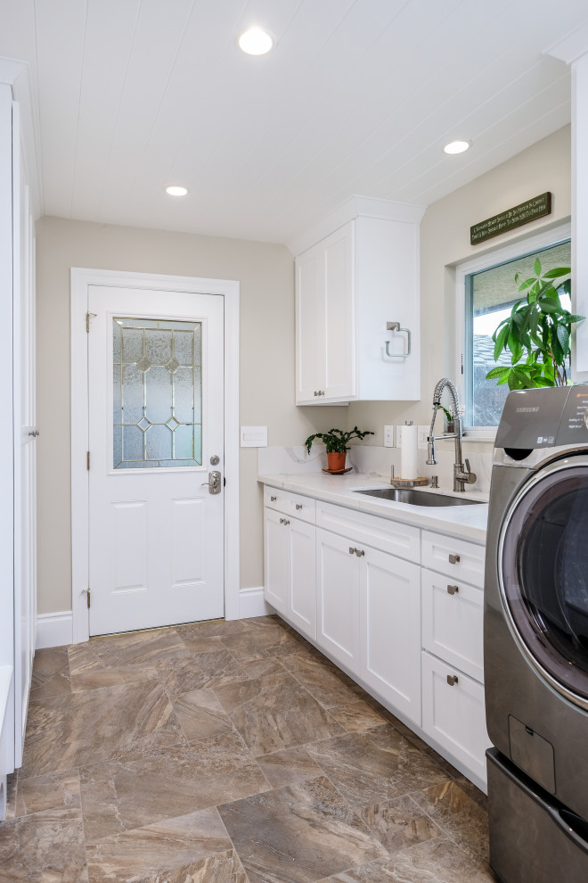 Design ideas for a mid-sized traditional galley dedicated laundry room in Sacramento with an undermount sink, shaker cabinets, white cabinets, quartz benchtops, white splashback, engineered quartz splashback, beige walls, porcelain floors, a side-by-side washer and dryer, brown floor, white benchtop and wood.