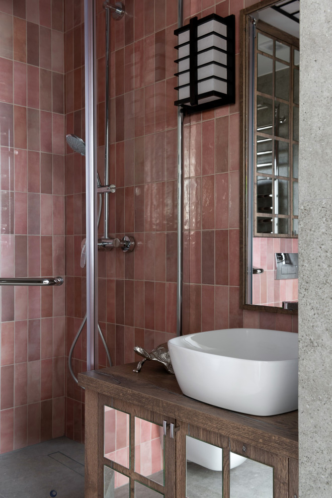 Пример оригинального дизайна: главная ванная комната среднего размера в восточном стиле с стеклянными фасадами, темными деревянными фасадами, угловым душем, инсталляцией, розовой плиткой, керамической плиткой, розовыми стенами, полом из керамогранита, накладной раковиной, столешницей из ламината, серым полом, душем с распашными дверями, коричневой столешницей, зеркалом с подсветкой, тумбой под одну раковину, напольной тумбой, балками на потолке и панелями на части стены