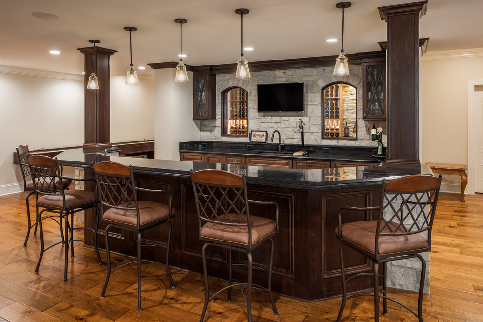 Large traditional seated home bar in Other with an undermount sink, raised-panel cabinets, dark wood cabinets, quartz benchtops, medium hardwood floors and brown floor.
