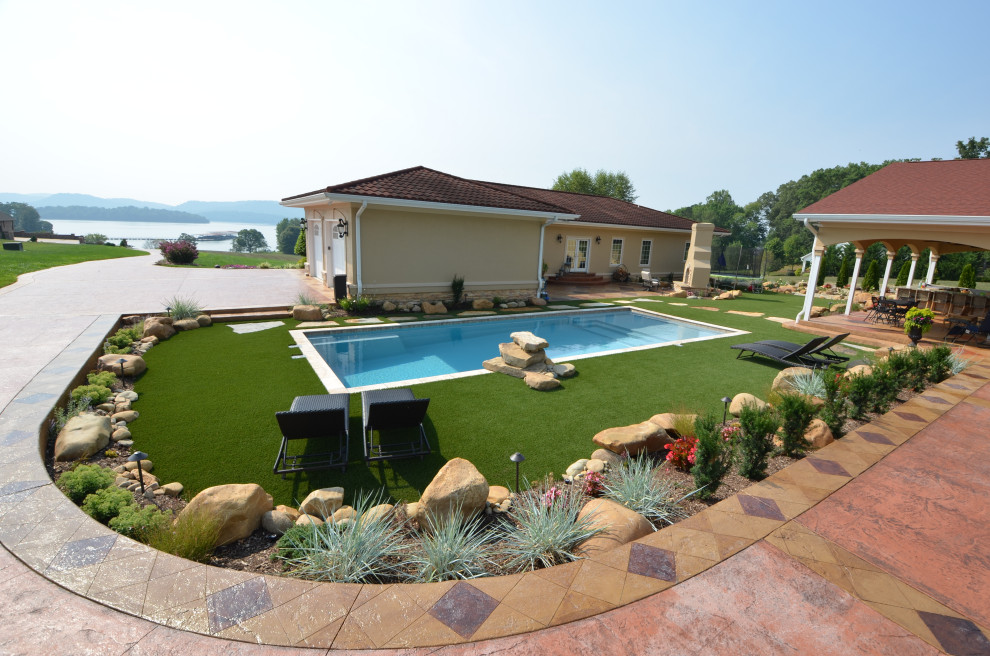 Mittelgroßer Mediterraner Pool hinter dem Haus in rechteckiger Form mit Natursteinplatten in Sonstige