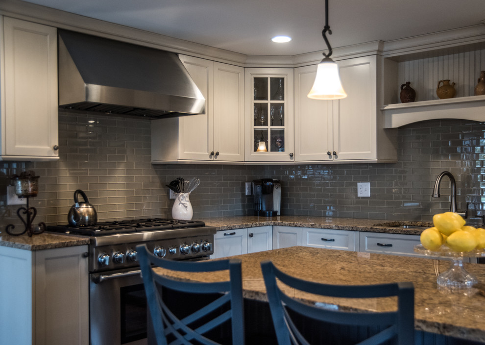 Mid-sized traditional l-shaped kitchen in Boston with shaker cabinets, stainless steel appliances and with island.