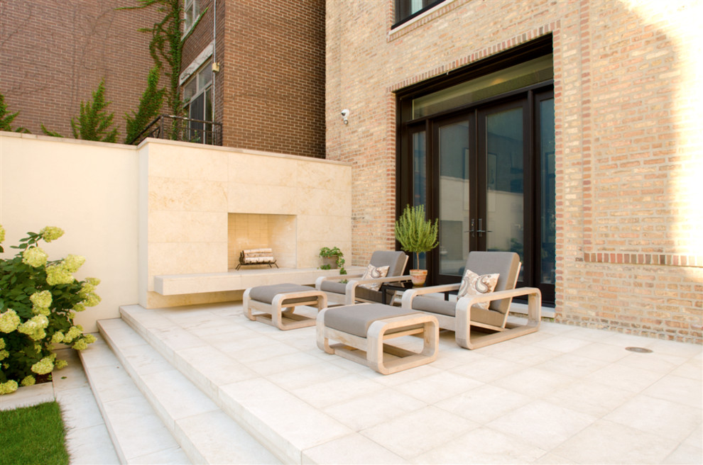 Large contemporary courtyard patio in Chicago with a fire feature, natural stone pavers and no cover.