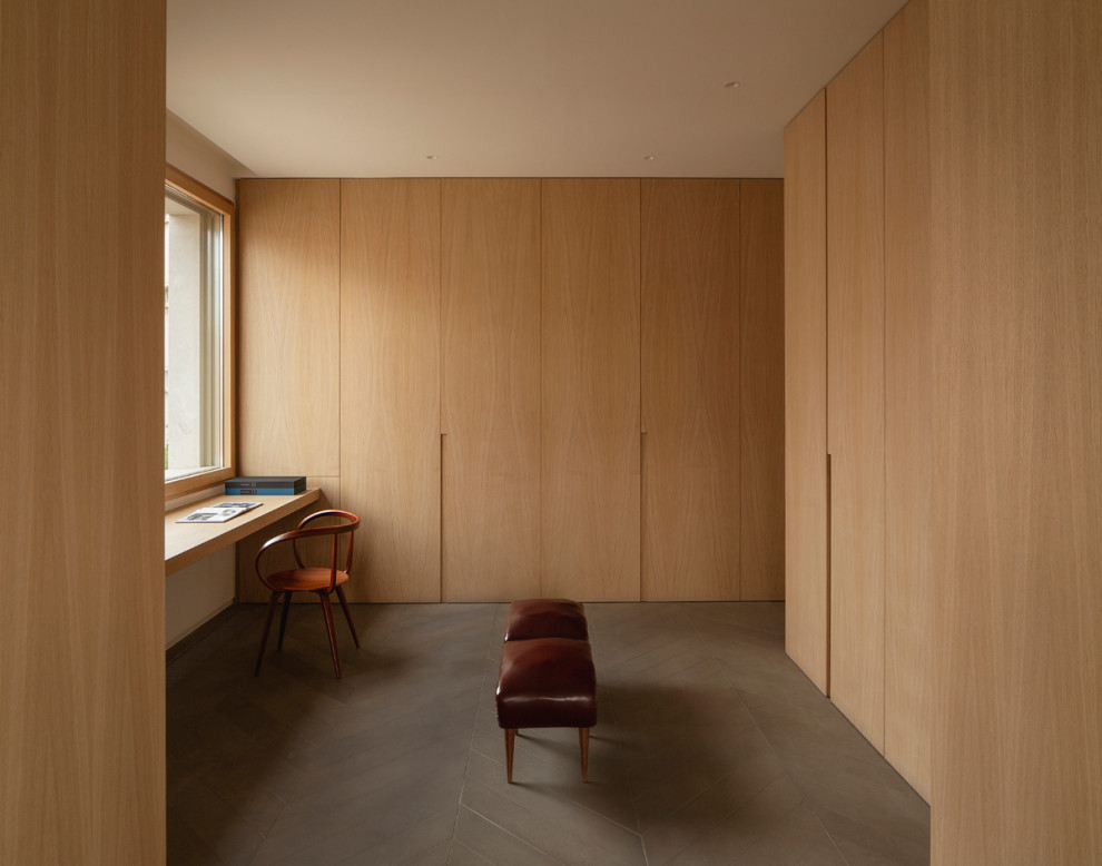 Ejemplo de despacho moderno de tamaño medio con paredes marrones, suelo de madera en tonos medios, escritorio empotrado, suelo gris, bandeja y panelado