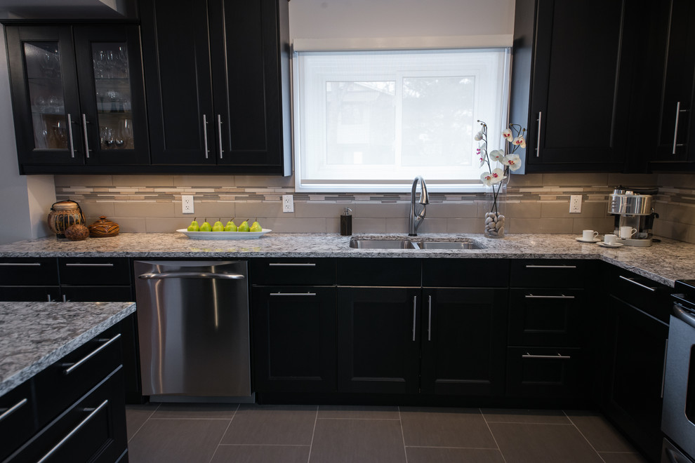 This is an example of a transitional eat-in kitchen in Ottawa with an undermount sink, recessed-panel cabinets, quartz benchtops, glass tile splashback, stainless steel appliances and porcelain floors.