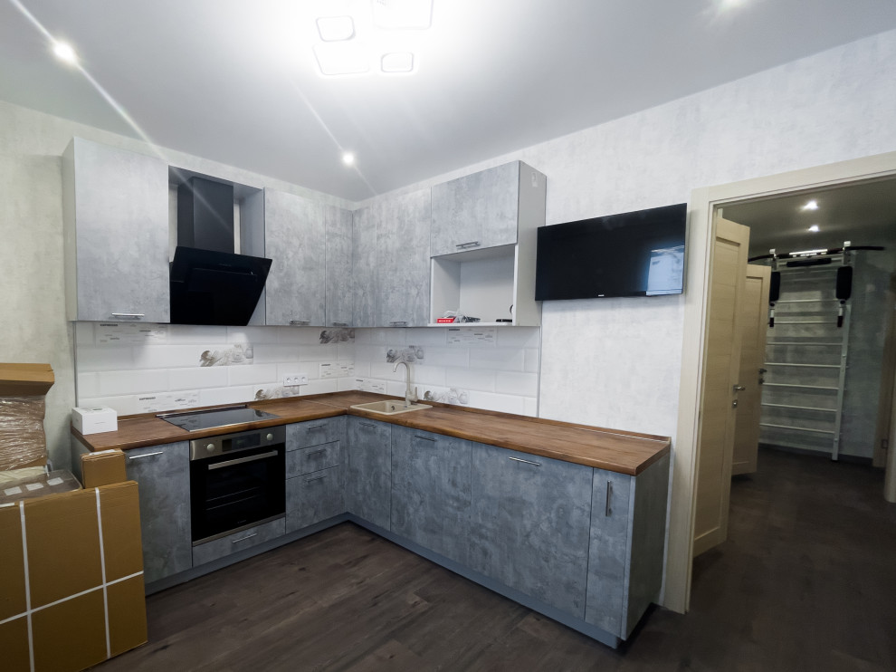 Design ideas for a mid-sized contemporary l-shaped separate kitchen in Moscow with a single-bowl sink, flat-panel cabinets, grey cabinets, wood benchtops, white splashback, ceramic splashback, panelled appliances, no island and brown benchtop.